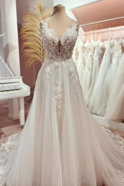 Robe de mariée longue en tulle et dentelle, coupe trapèze, col en V et traîne.