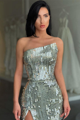 Robe de bal argentée à sequins, décolleté asymétrique et fente haute, encolure argentée tendance.