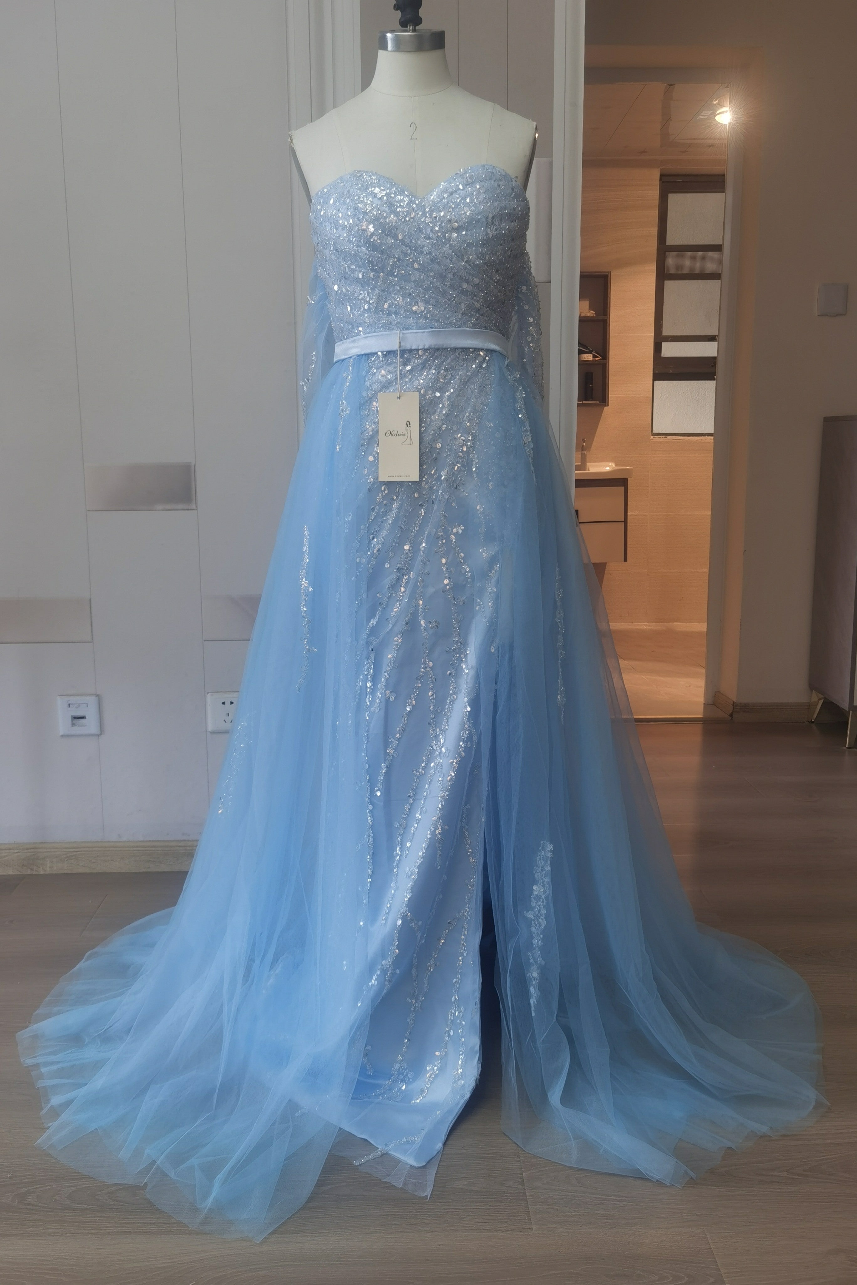 Robe de bal en tulle bleu ciel fendue sur le devant et épaules dénudées, ornée de sequins