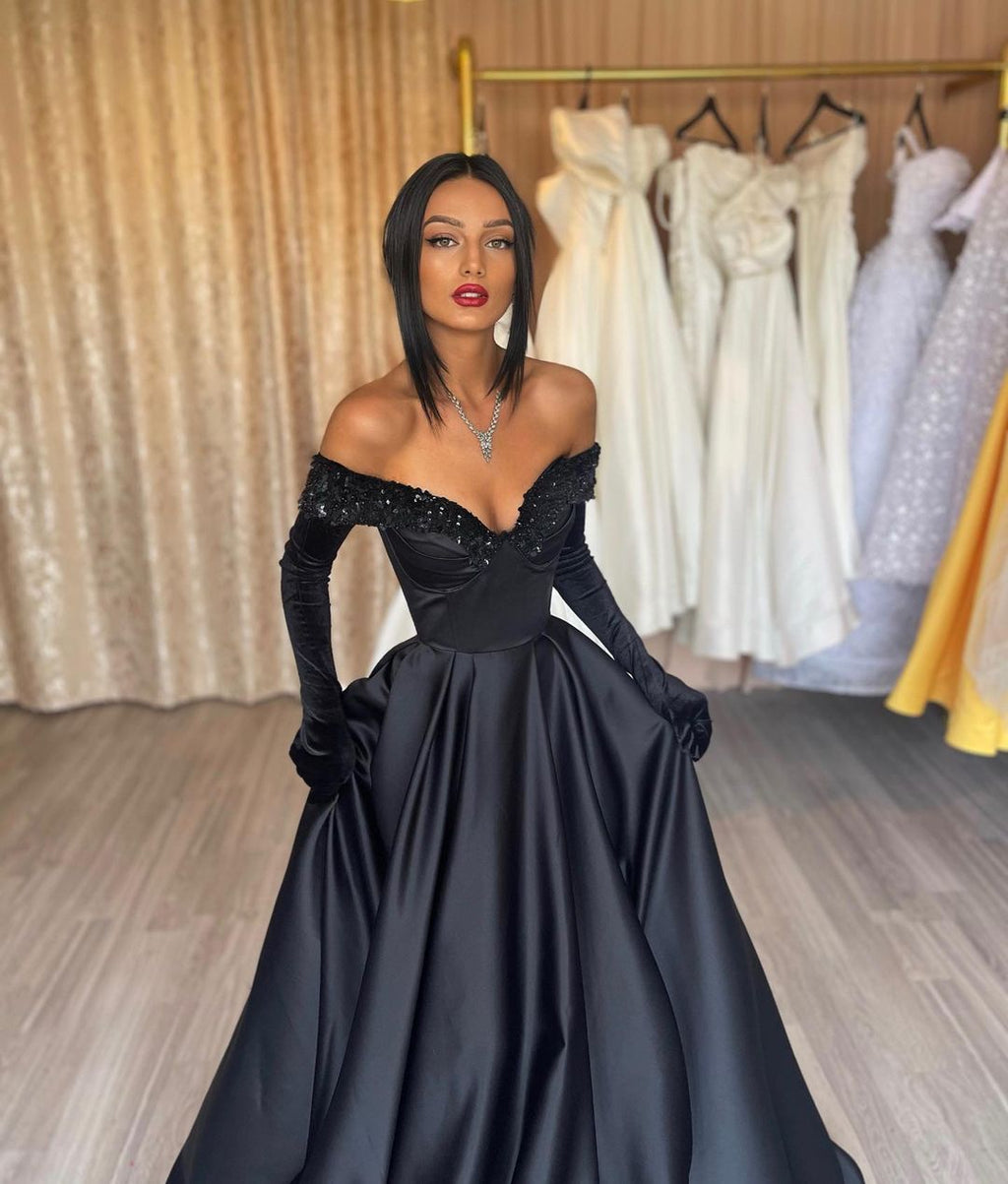 Robe de bal longue noire en satin, coupe trapèze, épaules dénudées, avec gants.