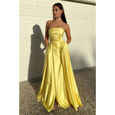 Vestido largo de fiesta amarillo satinado sin tirantes con abertura alta y bolsillos 