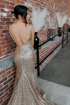 Robe de bal longue sirène à sequins champagne, décolleté plongeant en V et traîne.