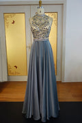 Robe de bal longue en mousseline de soie à col halter et perles de cristal, coupe trapèze, longueur au sol.