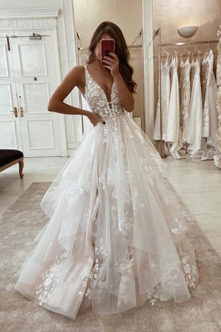 Elegante vestido de novia de corte A con escote en V, tirantes, apliques y encaje.
