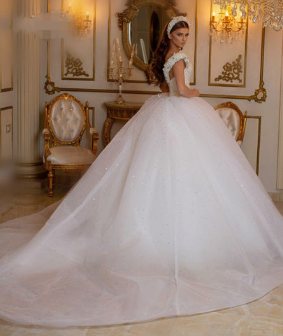 Robe de mariée longue princesse glamour à épaules dénudées, ornée de perles et de tulle, style perle et perles.