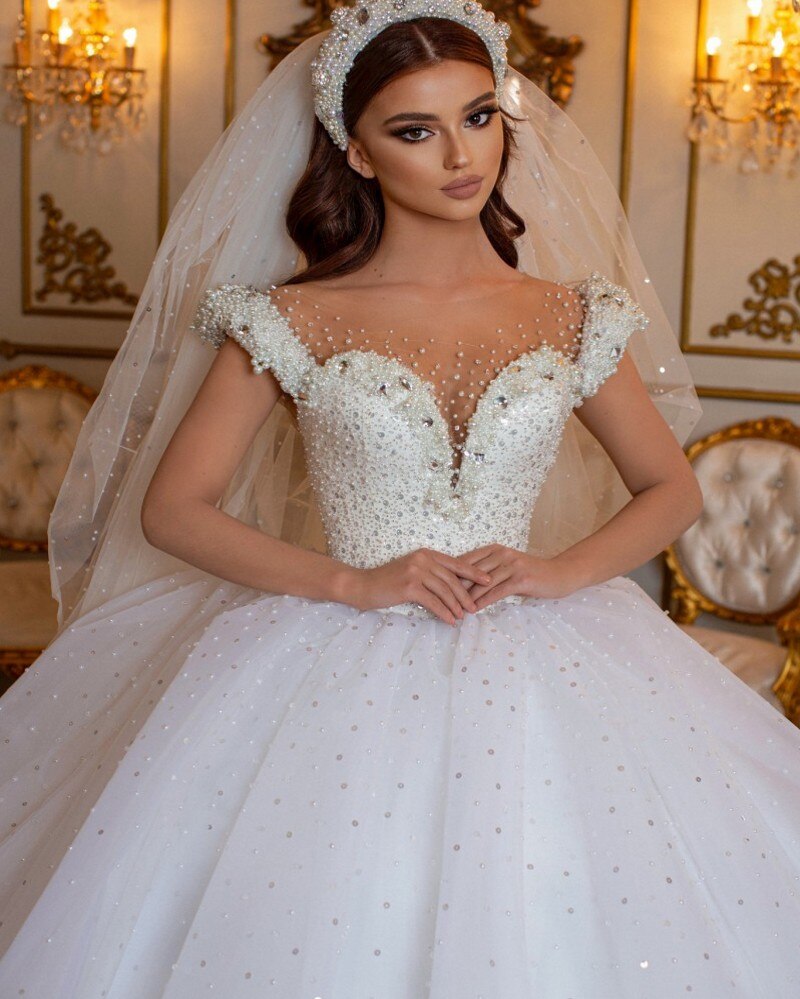 Robe de mariée longue princesse glamour à épaules dénudées, ornée de perles et de tulle, style perle et perles.