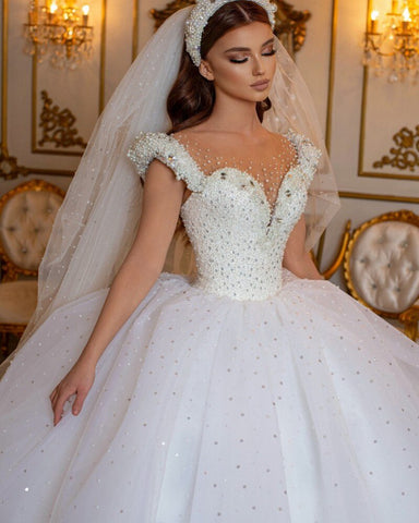 Robe de mariée longue princesse glamour à épaules dénudées, ornée de perles et de tulle, style perle et perles.