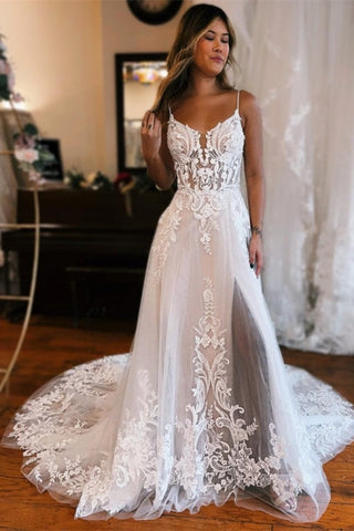 Robe de mariée longue blanche glamour, coupe trapèze, bretelles spaghetti, sans manches, en dentelle et fendue.