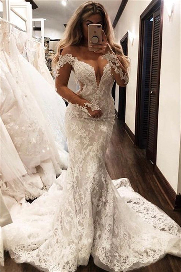 Vestido de novia sirena glamuroso con hombros descubiertos, mangas largas, escote en V y apliques.