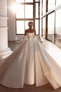 Robe de mariée glamour en satin blanc, coupe trapèze, ornée de perles et avec traîne