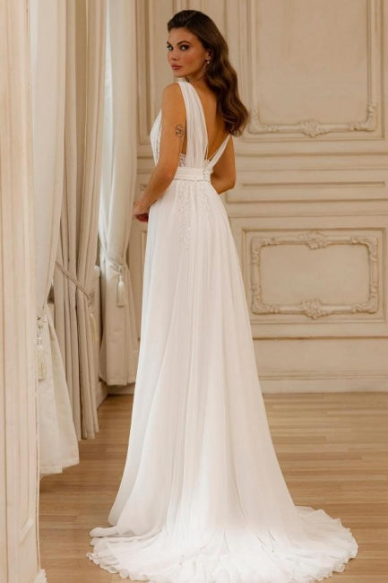 Magnifique robe de mariée blanche en mousseline de soie et dentelle, coupe trapèze, col en V, sans manches et dos nu.
