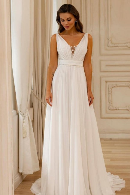 Magnifique robe de mariée blanche en mousseline de soie et dentelle, coupe trapèze, col en V, sans manches et dos nu.