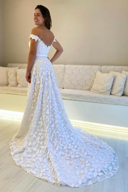 Magnifique robe de mariée blanche en dentelle, coupe trapèze, décolleté cœur, sans manches, ornée d'appliqués et dos nu.