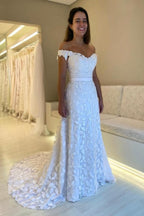 Magnifique robe de mariée blanche en dentelle, coupe trapèze, décolleté cœur, sans manches, ornée d'appliqués et dos nu.