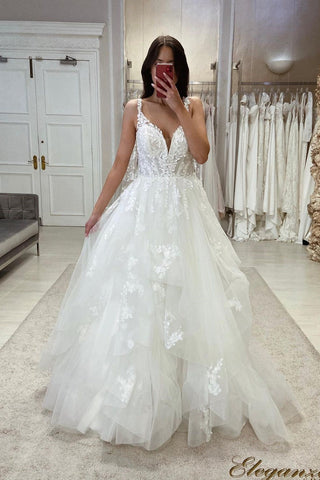 Precioso vestido de novia de corte A, tirantes finos, escote en V, sin mangas y con encaje.