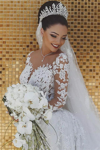 Precioso vestido de novia de sirena con encaje de cuentas en las mangas y apliques de tul transparente.