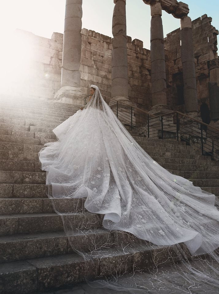 Magnifique robe de mariée princesse à manches longues et col transparent, ornée de perles et de fleurs.