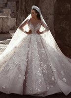 Magnifique robe de mariée princesse à manches longues et col transparent, ornée de perles et de fleurs.