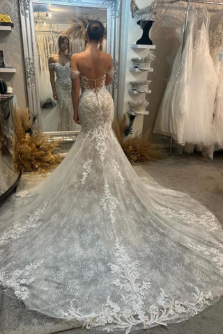 Precioso vestido de novia blanco sin mangas, de encaje, con hombros descubiertos, escote columna y cola con apliques.