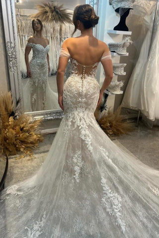 Precioso vestido de novia blanco sin mangas, de encaje, con hombros descubiertos, escote columna y cola con apliques.