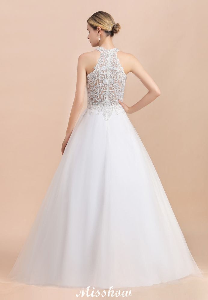 Magnifique robe de mariée dos nu ornée de strass, en tulle blanc et dentelle appliquée, coupe trapèze.