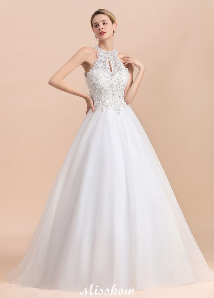 Magnifique robe de mariée dos nu ornée de strass, en tulle blanc et dentelle appliquée, coupe trapèze.