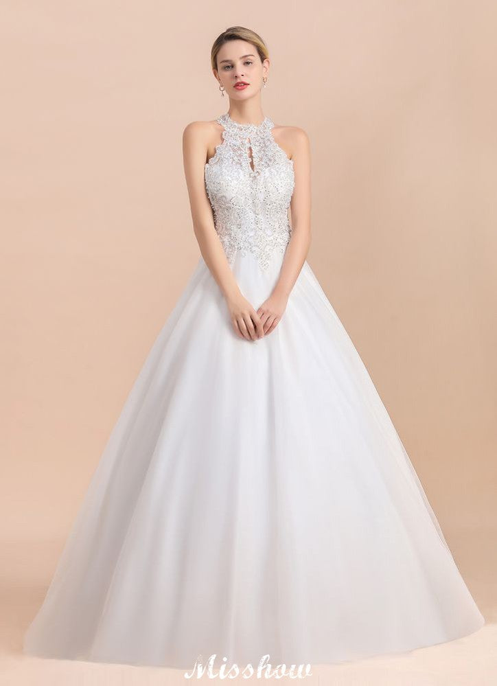 Magnifique robe de mariée dos nu ornée de strass, en tulle blanc et dentelle appliquée, coupe trapèze.