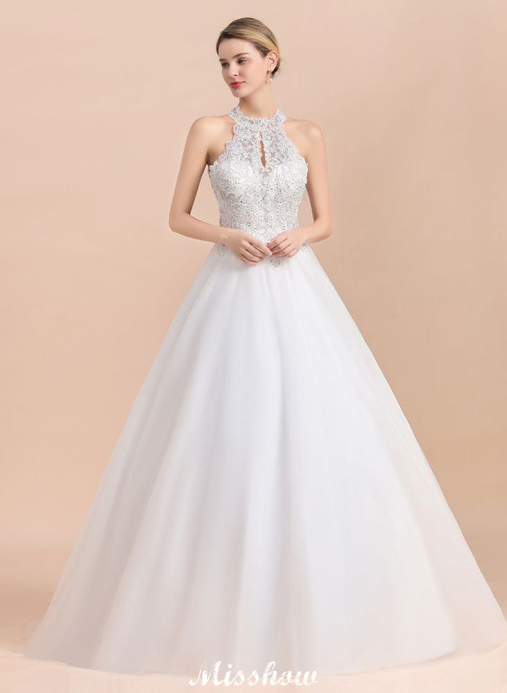 Magnifique robe de mariée dos nu ornée de strass, en tulle blanc et dentelle appliquée, coupe trapèze.
