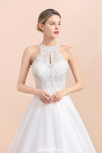 Magnifique robe de mariée dos nu ornée de strass, en tulle blanc et dentelle appliquée, coupe trapèze.