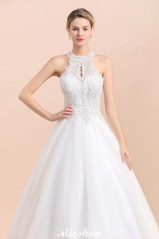 Magnifique robe de mariée dos nu ornée de strass, en tulle blanc et dentelle appliquée, coupe trapèze.