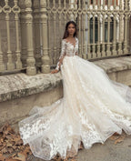 Precioso vestido de novia largo de corte A con escote barco, apliques, cola de encaje y mangas, con mangas y apliques.