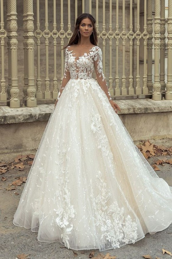 Precioso vestido de novia largo de corte A con escote barco, apliques, cola de encaje y mangas, con mangas y apliques.