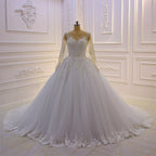 Precioso vestido de novia largo de corte A con escote barco, apliques de tul con perlas y encaje, con mangas.