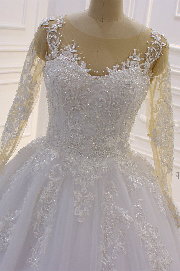Precioso vestido de novia largo de corte A con escote barco, apliques de tul con perlas y encaje, con mangas.