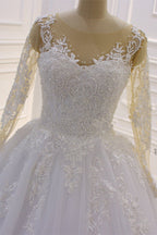 Precioso vestido de novia largo de corte A con escote barco, apliques de tul con perlas y encaje, con mangas.