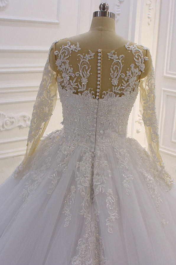 Precioso vestido de novia largo de corte A con escote barco, apliques de tul con perlas y encaje, con mangas.