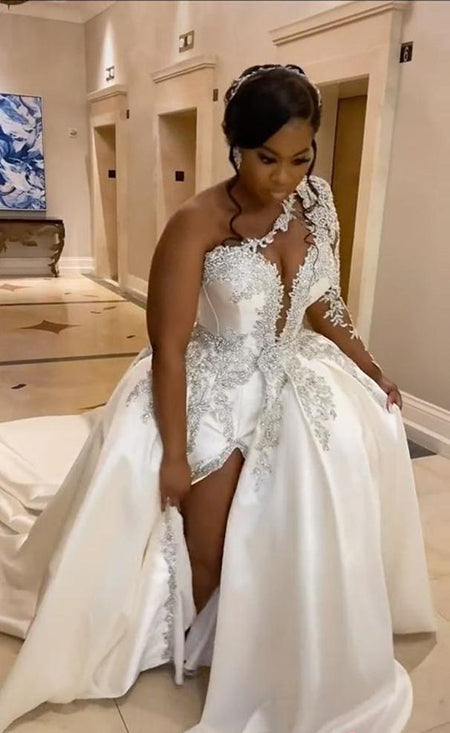 Magnifique robe de mariée longue trapèze asymétrique à une épaule, ornée de perles et fendue.