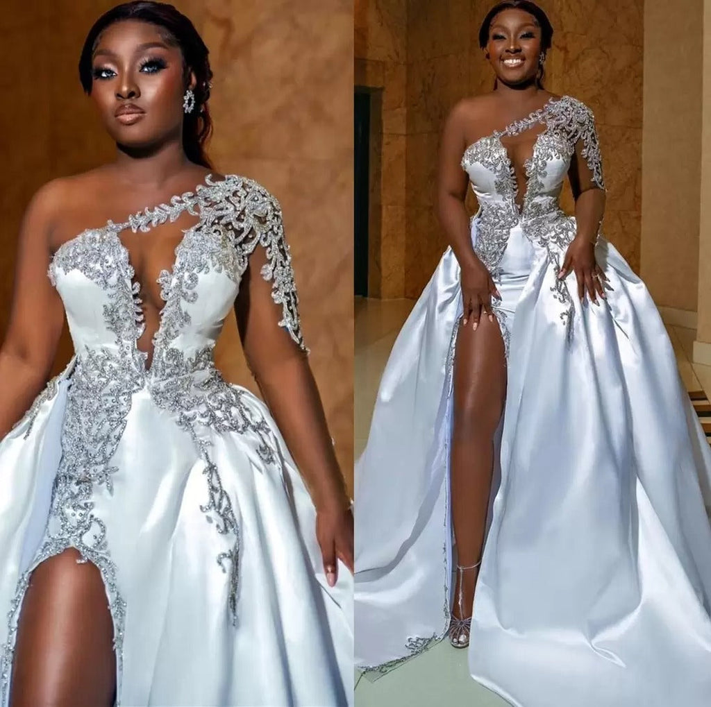 Magnifique robe de mariée longue trapèze asymétrique à une épaule, ornée de perles et fendue.
