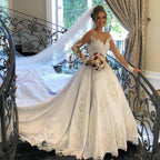 Magnifique robe de mariée longue en satin, dentelle et tulle, coupe trapèze, décolleté cœur et manches