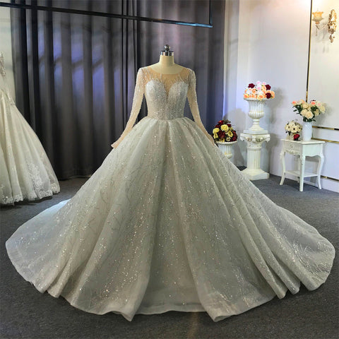 Precioso vestido de novia largo de corte princesa con mangas, estilo barco y cristales.