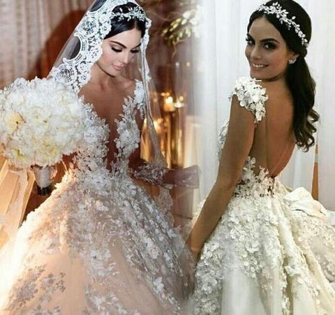 Precioso vestido de novia largo estilo princesa con escote barco, apliques de encaje, espalda descubierta, volantes y mangas.