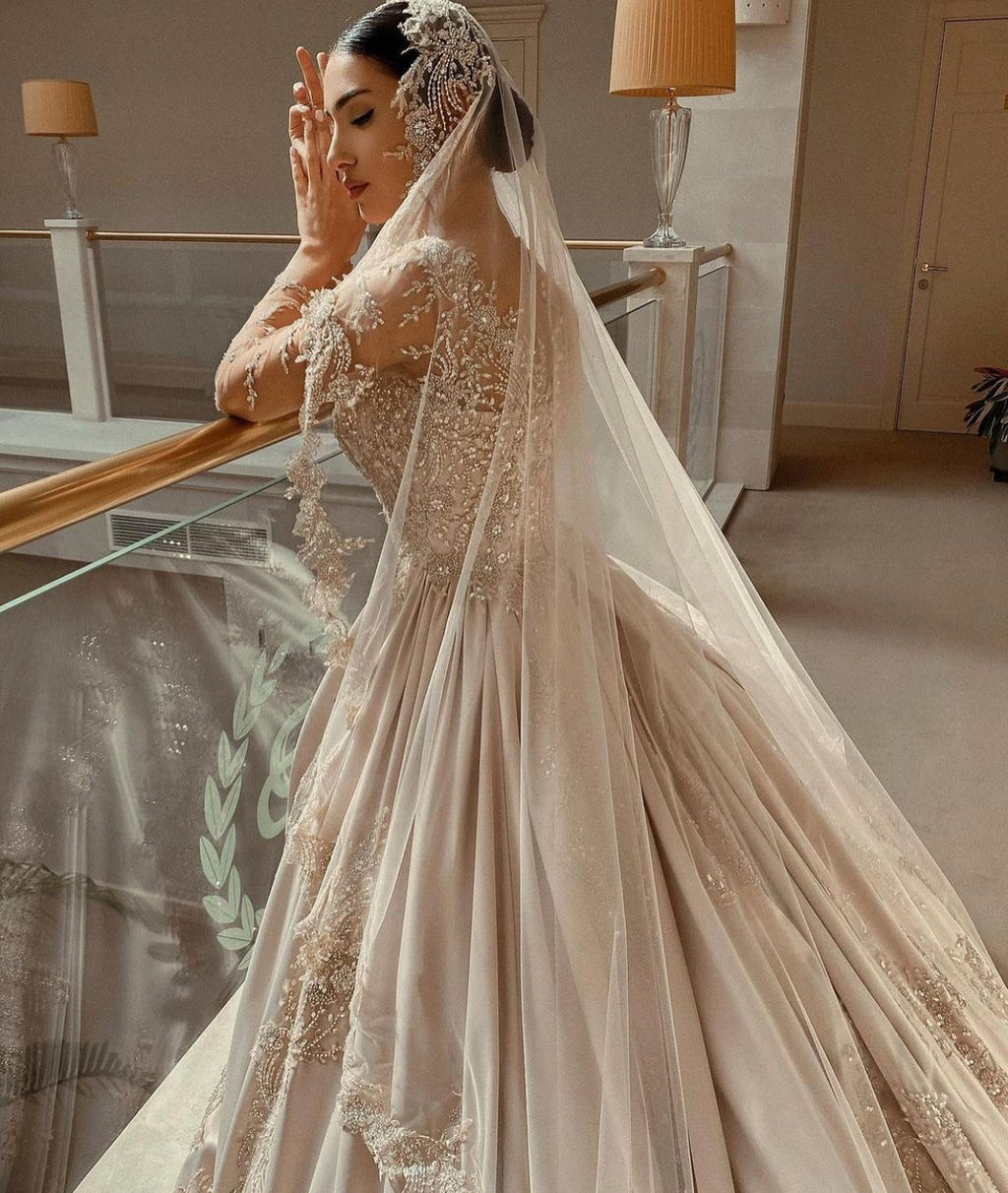Magnifique robe de mariée longue princesse en satin perlé avec manches et décolleté cœur