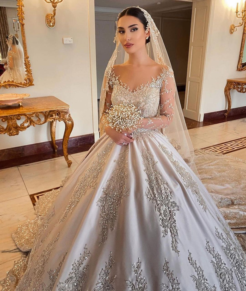 Magnifique robe de mariée longue princesse en satin perlé avec manches et décolleté cœur