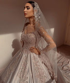 Magnifique robe de mariée longue princesse en satin perlé avec manches et décolleté cœur