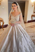 Magnifique robe de mariée longue princesse en satin perlé avec manches et décolleté cœur