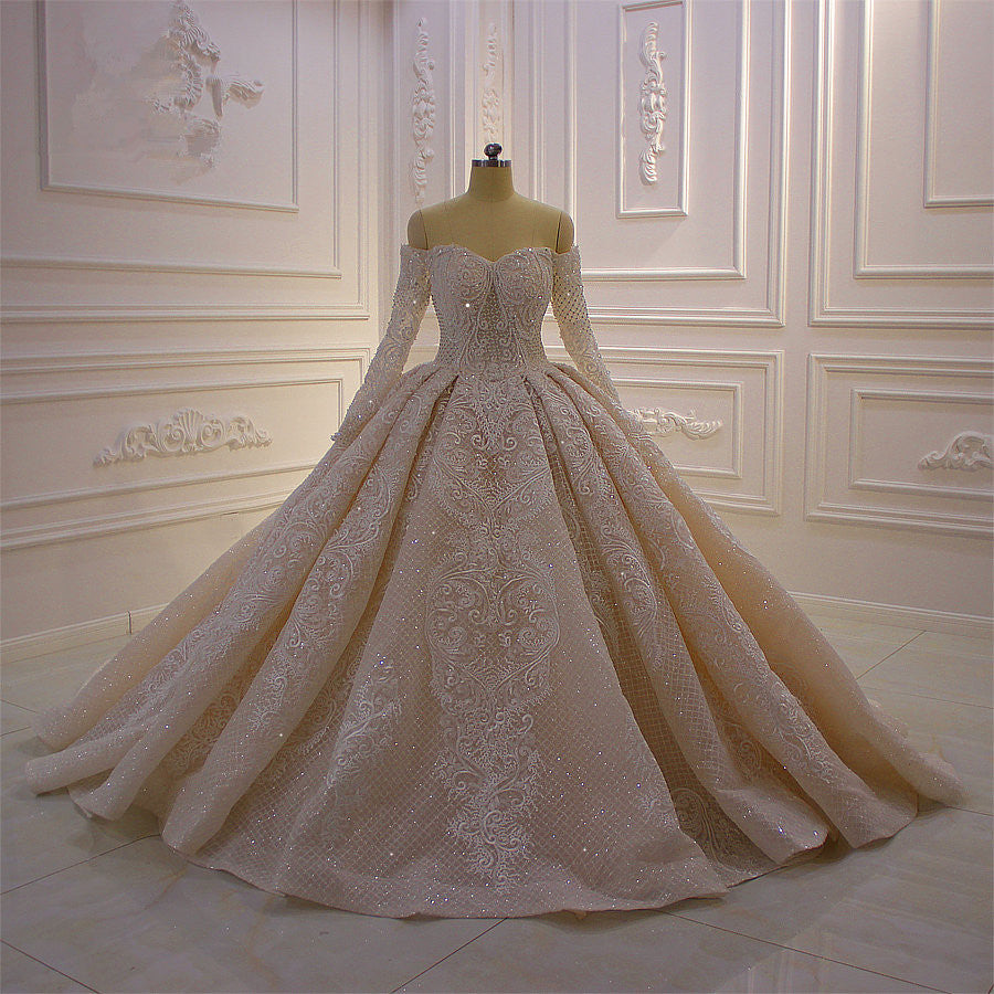 Precioso vestido de novia de corte princesa con apliques de encaje, manga larga y hombros descubiertos