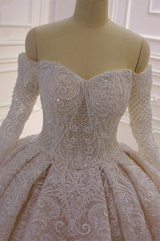 Precioso vestido de novia de corte princesa con apliques de encaje, manga larga y hombros descubiertos