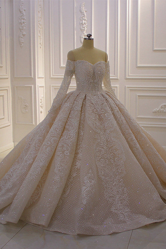 Precioso vestido de novia de corte princesa con apliques de encaje, manga larga y hombros descubiertos