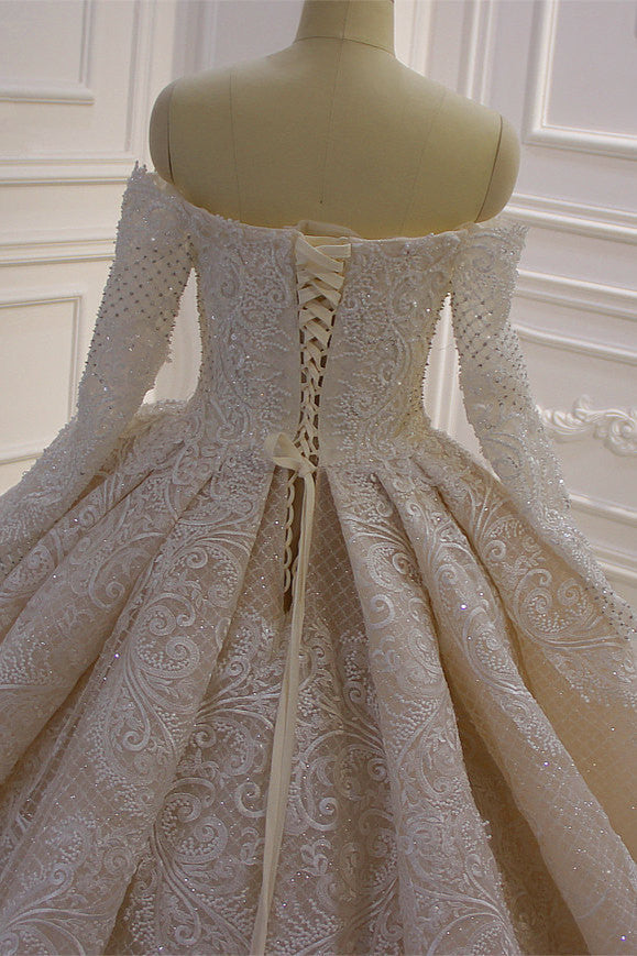 Precioso vestido de novia de corte princesa con apliques de encaje, manga larga y hombros descubiertos