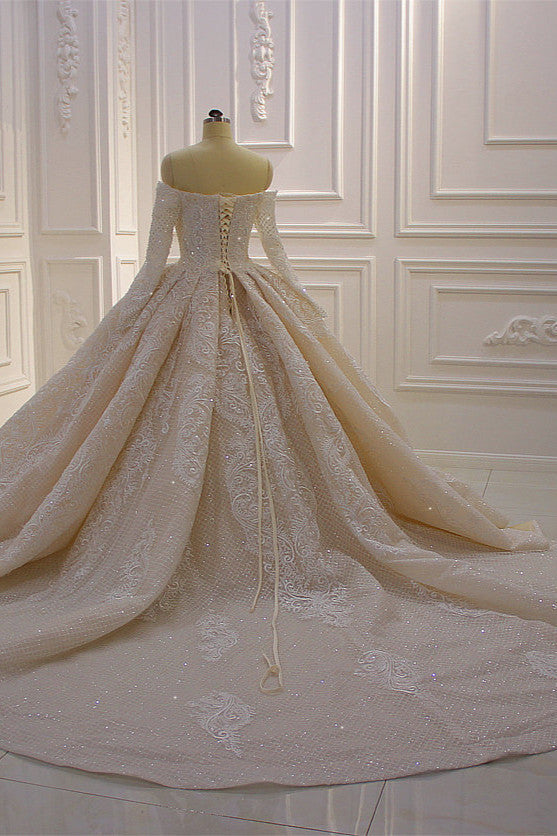 Precioso vestido de novia de corte princesa con apliques de encaje, manga larga y hombros descubiertos